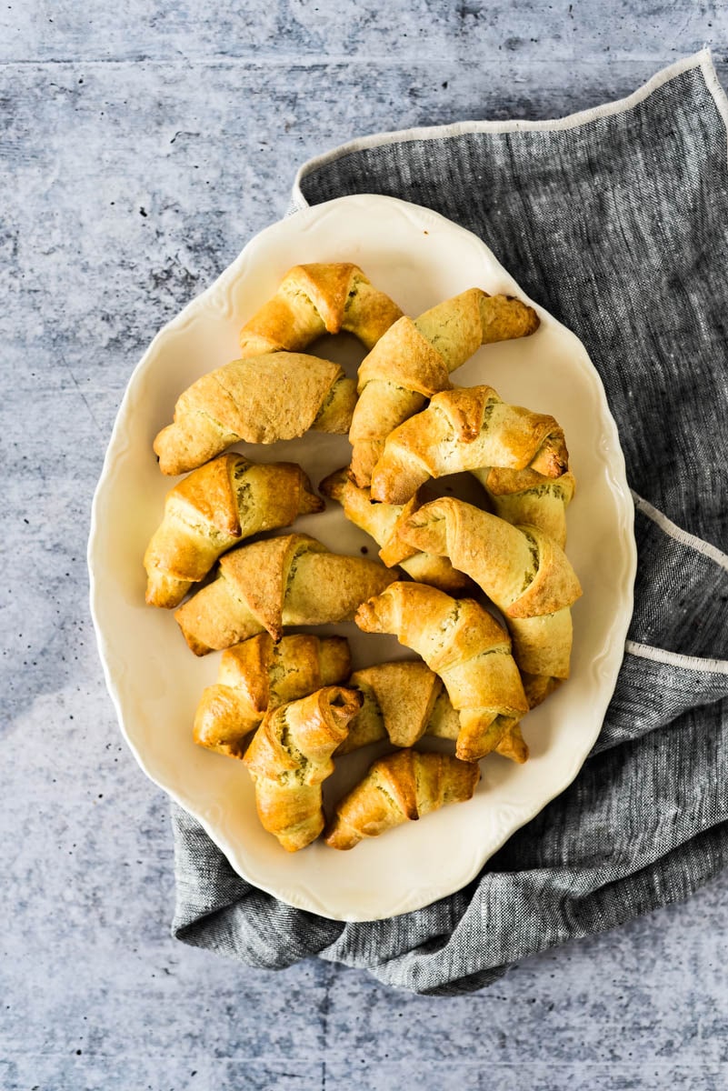 sourdough crescent rolls in white bowl with napkin