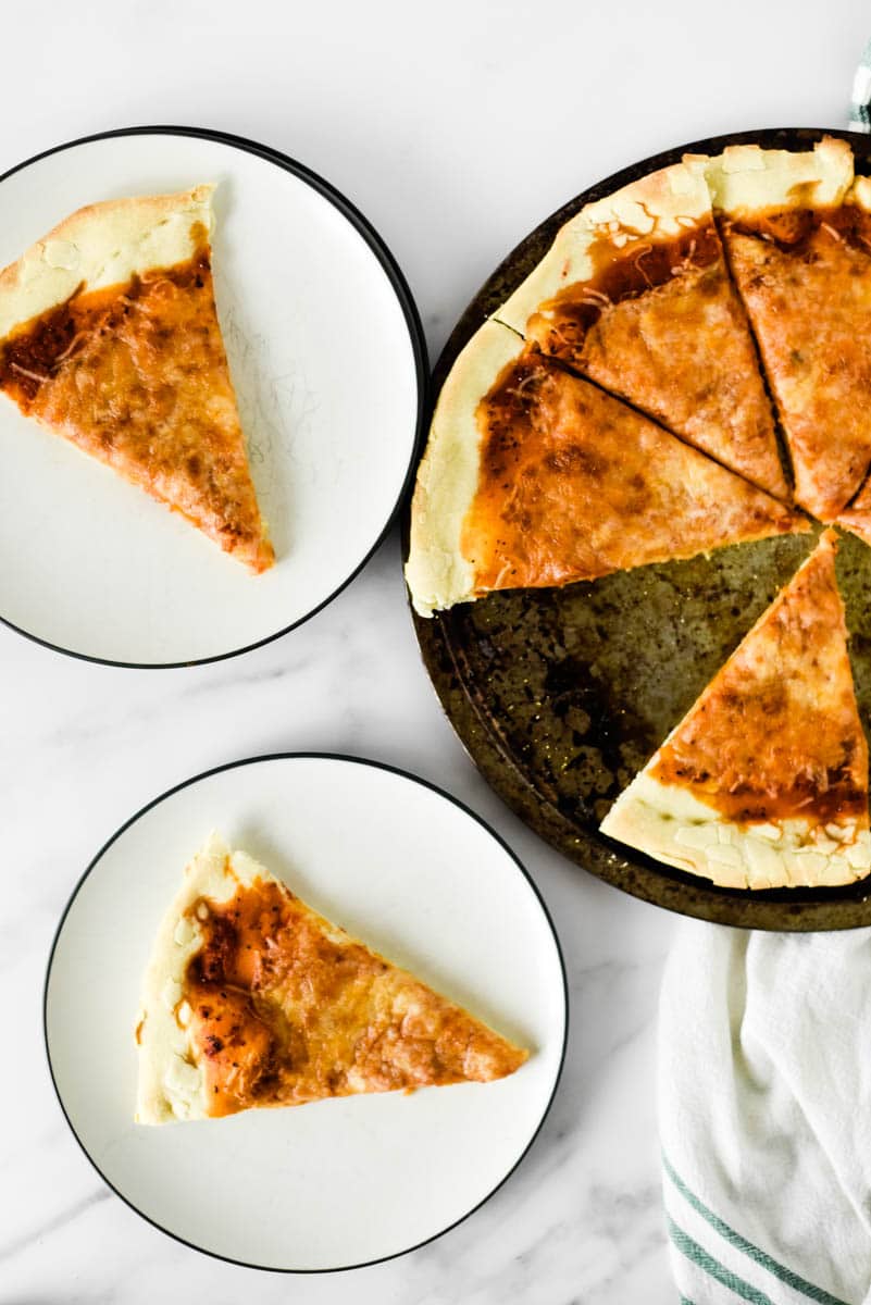 slices of cheese pizza with sourdough crust next to pizza